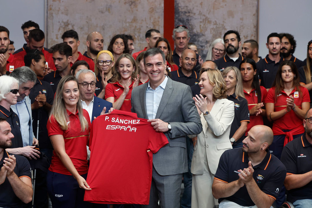 El presidente del Gobierno español, Pedro Sánchez, recibe una camiseta de manos de la deportista Fátima Gálvez durante  la recepción a los equipos olímpico y paralímpico participantes en los Juegos Olímpicos y Paralímpicos de París 2024, este martes en el Complejo de la Moncloa. EFE/ Sergio Perez