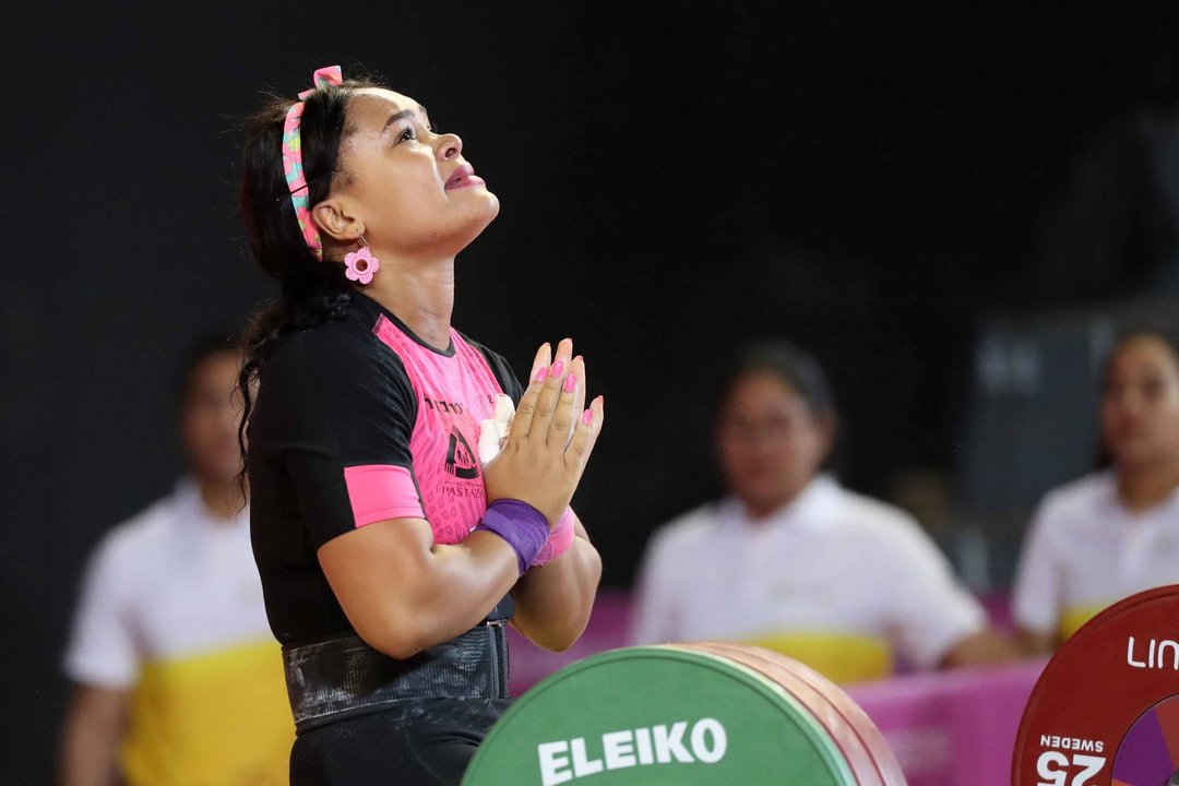 Fotografía de archivo, tomada el 27 de julio de 2019, en la que se registró a la pesista ecuatoriana Neisi Dajomes al encomendarse a Dios, antes de competir en la prueba femenina de halterorilia para la categoría de los 76 kg de los Juegos Panamericanos, en Lima (Perú). EFE/Paolo Aguilar