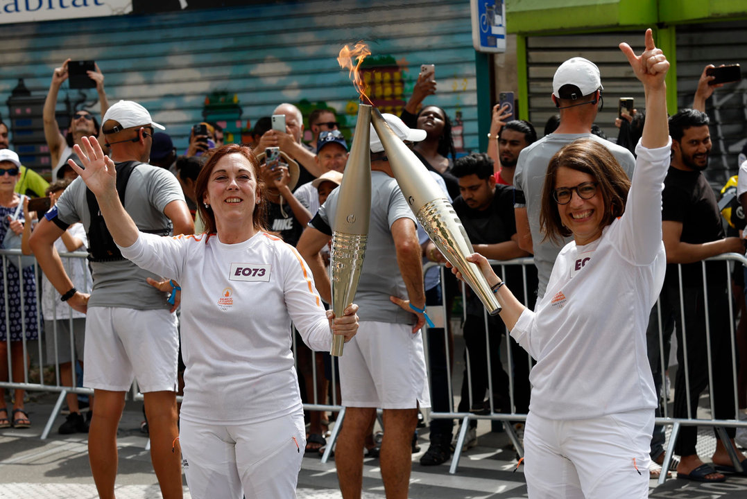 La periodista del departamento de deportes de la Agencia EFE Natalia Arriaga (i), este jueves en el relevo de la antorcha olímpica de París 2024. EFE/Julio Muñoz