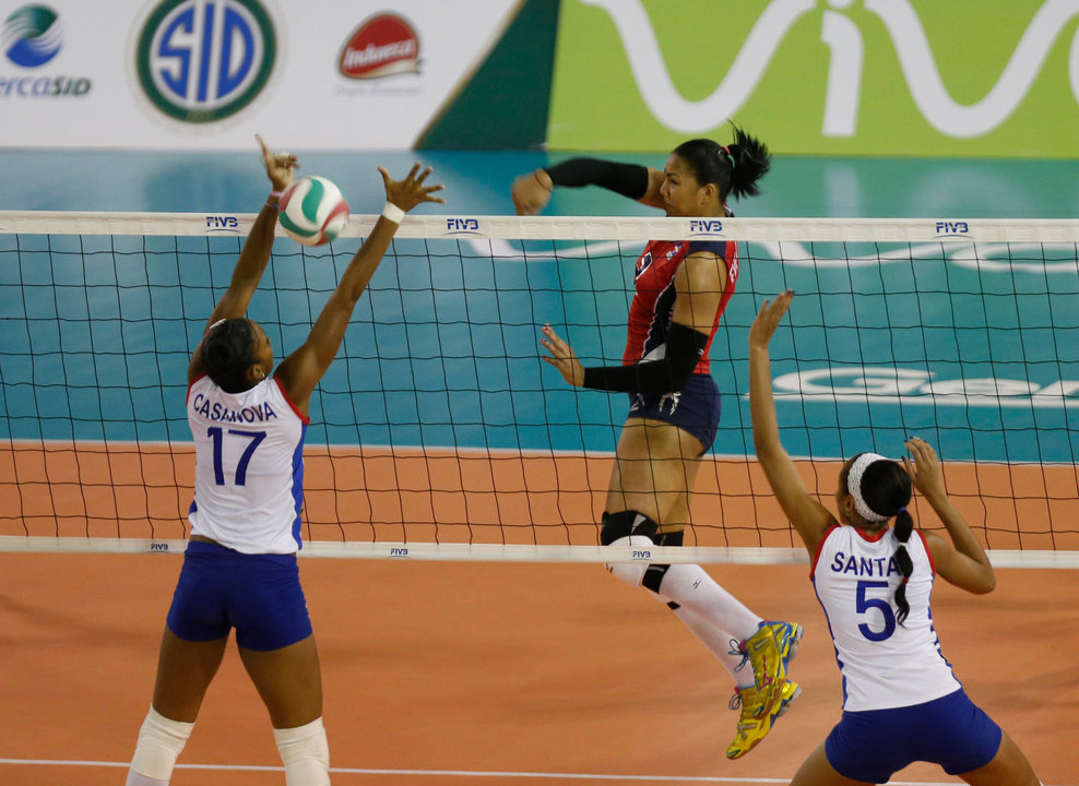 Fotografía de archivo de la dominicana Lisvel Eve Mejía, quien remata ante las cubanas Heidy Casanova (i) y Yamila Hernández Santas. Mejía dio positivo en una prueba de dopaje y se perderá los Juegos Olímpicos. EFE/Orlando Barría