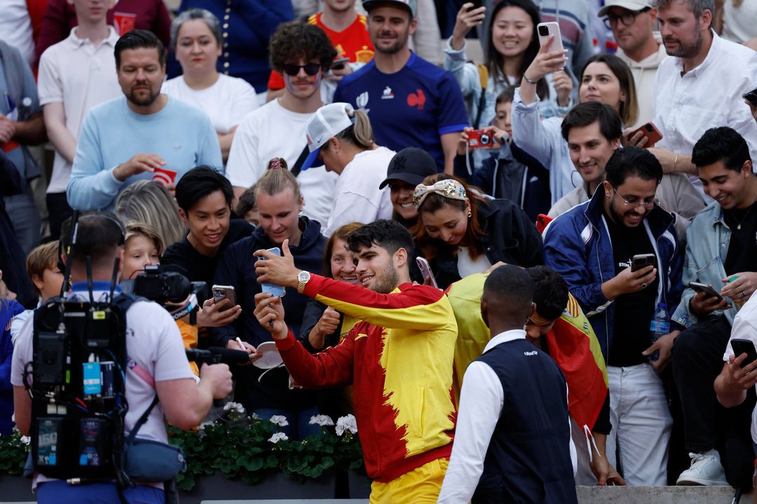 El tenista español Carlos Alcaraz firma autógrafos tras vencer por 6-3 y 6-1, en una hora y siete minutos, al libanés Hady Habib, al finalizar su partido de la primera ronda individual masculino de tenis de los Juegos Olímpicos de París 2024 este sábado en París. EFE/ Juanjo Martín