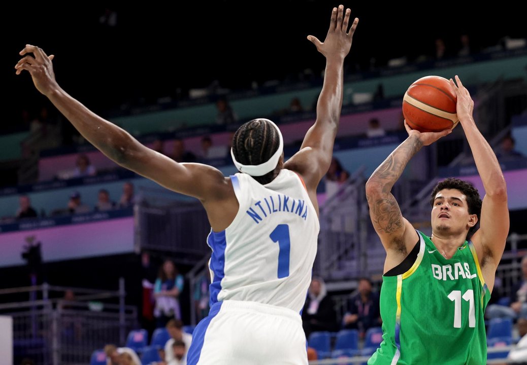 El brasileño Gui Santos (d) trata e lanzar pesar a la defensa del francés Frank Ntilikina en el debut de Francia y Brasil en el Pierre Mauroy Stadium en Villeneuve-d'Ascq, Francia. EFE/EPA/ALEX PLAVEVSKI