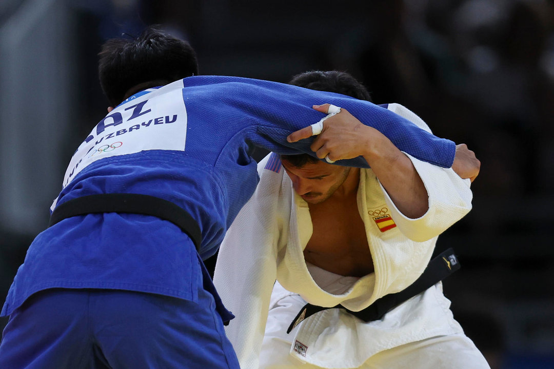 El judoca español David García Tomé (blanco) se enfrenta al kazajo Gusman Kyrgyzbayev durante su combate eliminatorio de judo masculino en la categoría de -66 kilos de los Juegos Olímpicos de París 2024 este domingo en París. EFE/ Miguel Gutiérrez