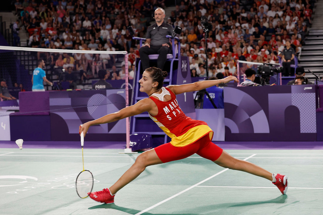 La jugadora de bádminton española Carolina Marín devuelve la pluma a la suiza Jenjira Stadelmann durante su partido de la fase de grupos de la competición de bádminton femenino individual de los Juegos Olímpicos de París 2024 este domingo en el pabellón Arena Porte de Chapelle en París, Francia. EFE/ Julio Muñoz