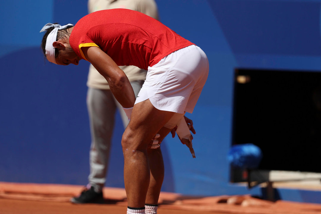 El tenista español Rafa Nadal se toca el muslo tras una jugada ante el serbio Novak Djokovic durante el partido celebrado en el marco de los Juegos Olímpicos de París, este lunes. EFE/ Juanjo Martín