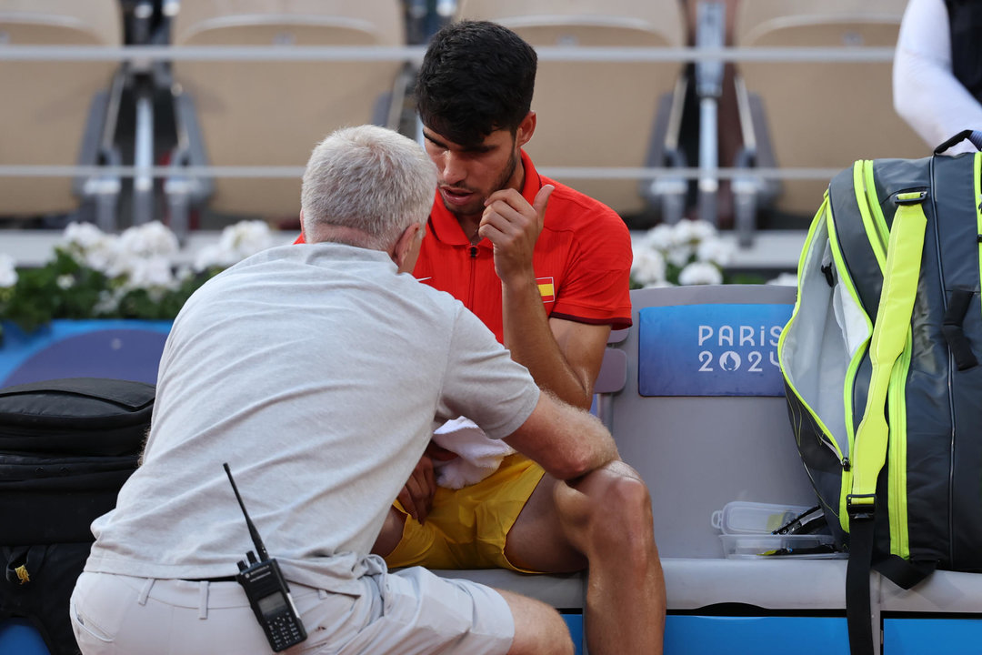 El tenista español Carlos Alcaraz pide tiempo médico ante el holandés Tallon Griekspoor durante el partido de tenis de segunda ronda individual masculino celebrado en el marco de los Juegos Olímpicos de París, en la pista Pista Philippe-Chatrier de la capital francesa. EFE/ Juanjo Martín