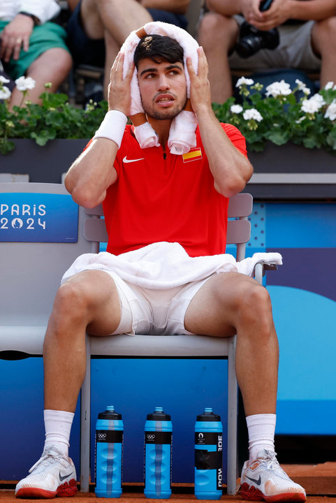 El tenista español Carlos Alcaraz descansa ante la pareja de Países Bajos compuesta por Wesley Koolhof y Tallon Griekspoor este martes, durante el partido de segunda ronda de dobles masculino de tenis, parte de los Juegos Olímpicos de París 2024, en la capital francesa. EFE/ Juanjo Martín