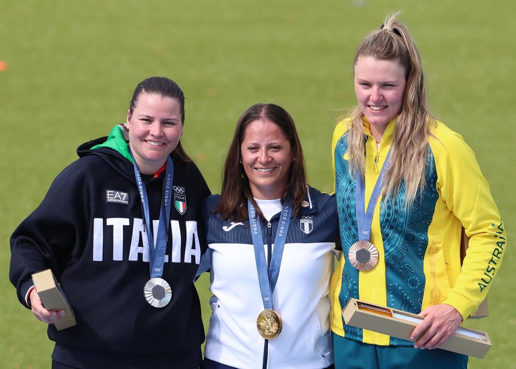 (I-D) La italiana y medallista de plata Silvana Maria Stanco, la nueva campeona olímpica la guatemalteca Adriana Ruano Oliva y la australiana Penny Smith, bronce, en el podido del campo de tiro de Chateauroux, Francia. EFE/EPA/VASSIL DONEV