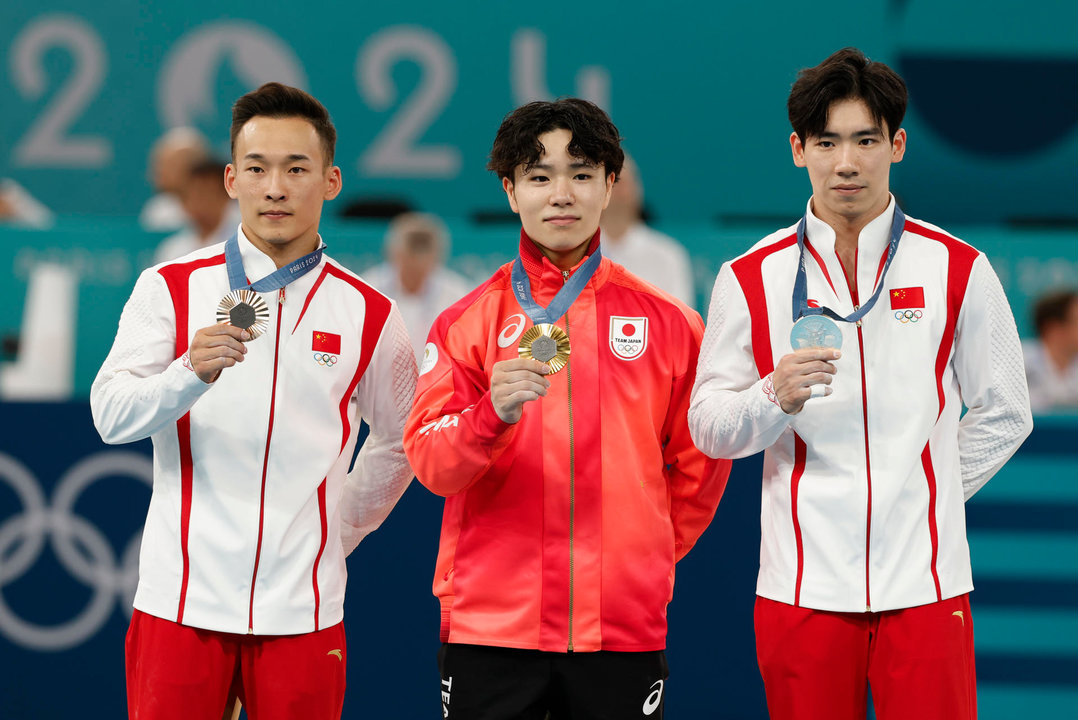 Los medallistas, el japonés Shinnosuke Oka (c-oro), y los chinos, Boheng Zhang (plata-d) y Routeng Xiao (i-bronce), posan en la final de Concurso Completo Masculino de Gimnasia Artística, parte de los Juegos Olímpicos de París 2024 este miércoles, en el Bercy Arena de la capital francesa. EFE/ Julio Muñoz