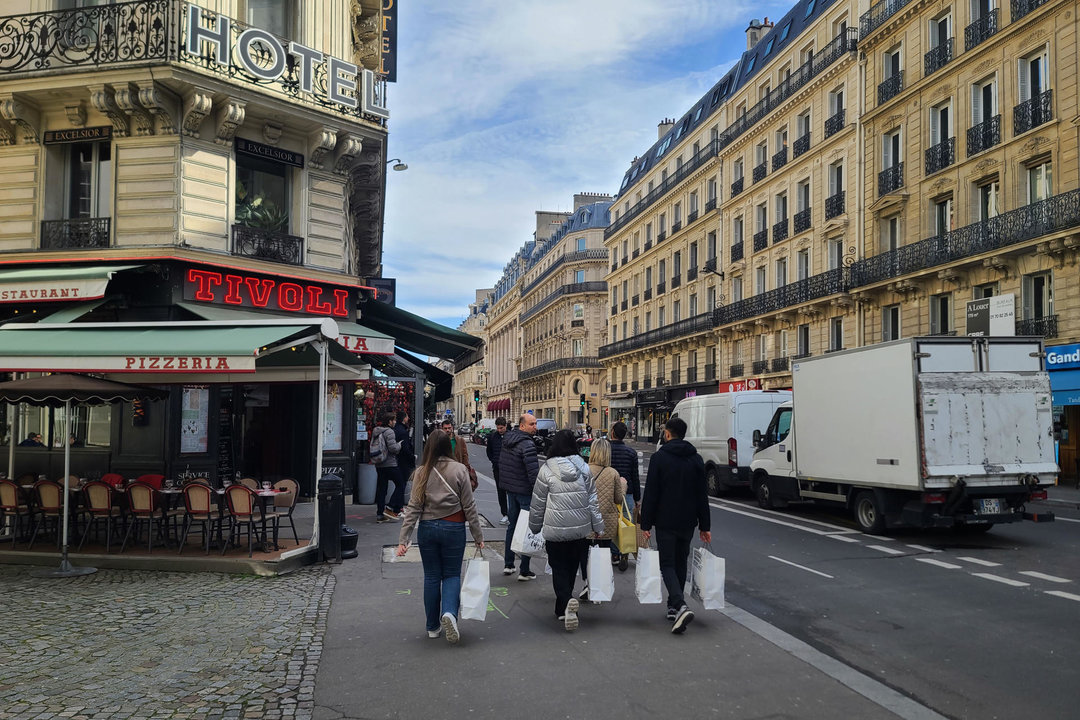 Los Juegos Olímpicos están demostrando su capacidad de atraer a turistas extranjeros a París, con un aumento del 8 % respecto al pasado año. En la imagen, turistas cargados con bolsas pasan por delante de un hotel situado en el centro de París. EFE/Edgar Sapiña Manchado