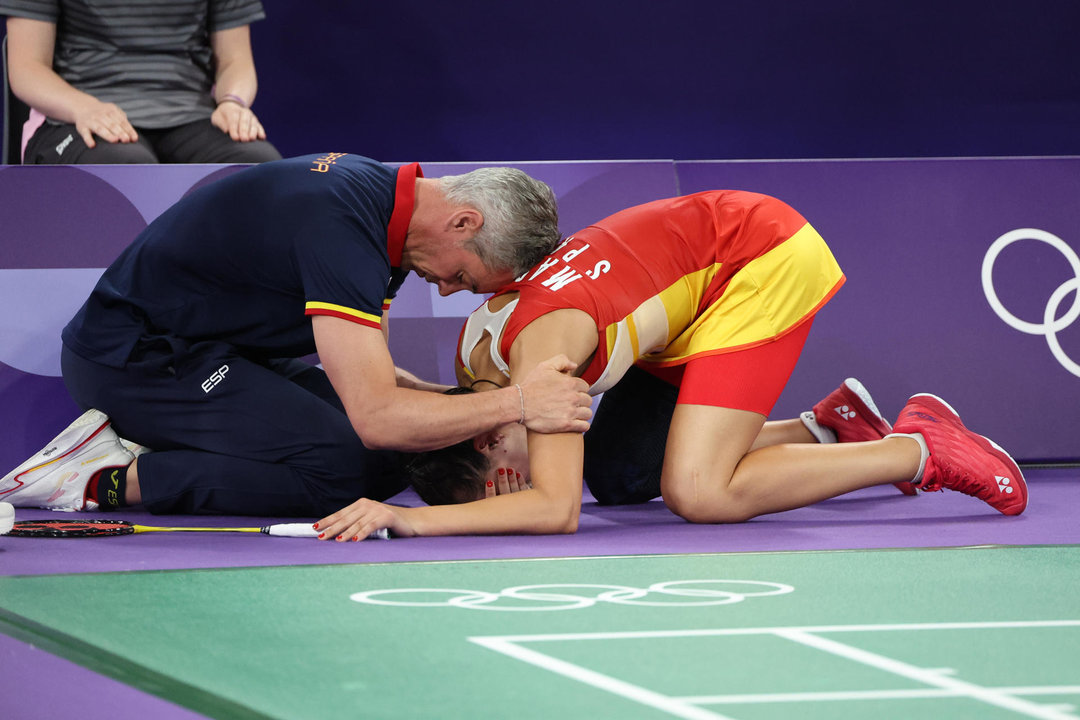 Carolina Marín recibe es consolada por su entrenador Fernando Rivas (i) tras lesionarse en la rodilla derecha durante su partido de semifinales de bádminton ante He Bing Jiao, de China. EFE/ Miguel Gutiérrez