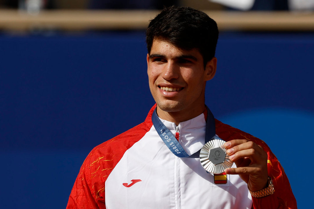 El tenista español Carlos Alcaraz posa con la medalla de plata tras la final individual masculina de tenis de los Juegos Olímpicos de París 2024 este domingo, en la capital gala. EFE/Juanjo Martín