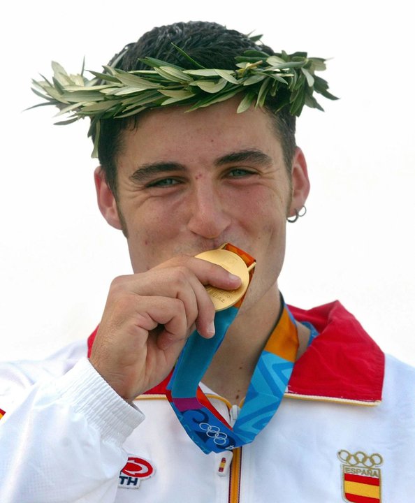 El palista español David Cal besa la medalla de oro que consiguió al vencer en la final de C1 1.000 metros de piragüismo de los Juegos Olímpicos de Atenas 2004, con un tiempo de 3:46.201. EFE/Manuel Bruque