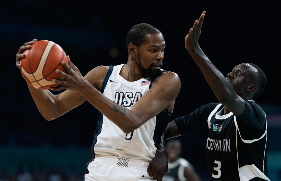 El estadounidense Kevin Durant (i), que busca un inédito cuarto oro olímpico, ante Majok Deng, durante el partido que enfrentó a su equipo con Sudán del Sur en la fase previa del torneo de baloncesto de los Juegos de París 2024 en el estadio Pierre Mauroy de Villeneuve-d'Ascq. EFE/EPA/ALEX PLAVEVSKI