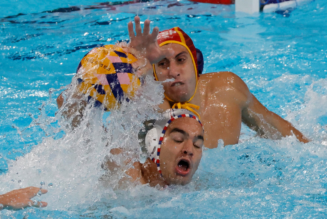 El jugador francés Romain Marion en acción ante el portero Unai Aguirre (atras) de España durante el partido de la ronda preliminar de waterpolo de los Juegos Olímpicos París 2024, que Francia y España disputaron en Nanterre, Francia.   EFE/ Lavandeira Jr