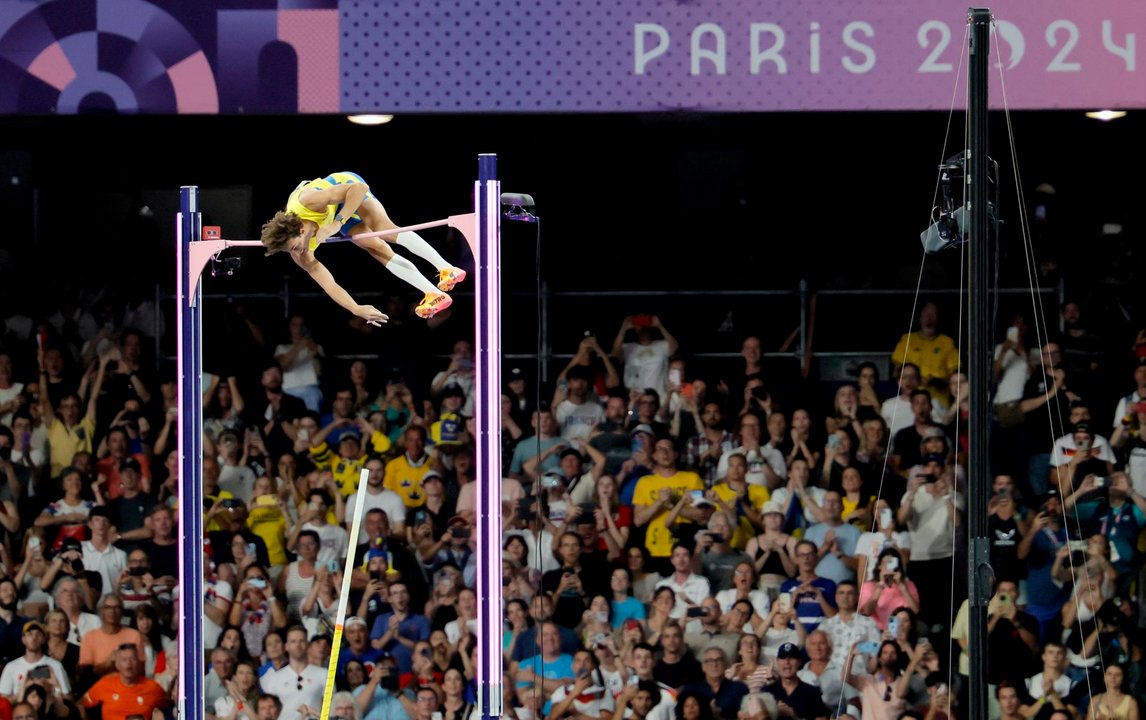 El atleta sueco Armand Duplantis consigue la medalla de oro y un nuevo récord del mundo en la final masculina de salto con pértiga, en los Juegos Olímpicos de París 2024 en el Estadio de Francia, este lunes, en la capital gala.  EFE/EPA/RONALD WITTEK