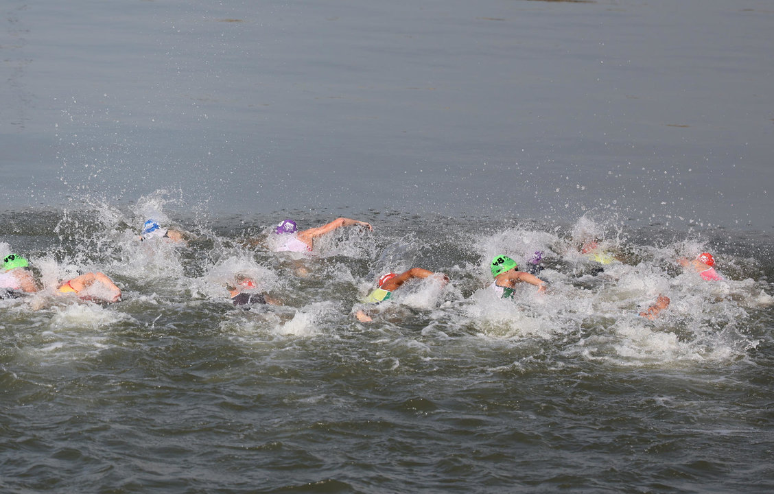 Un grupo de triatletas nadan el primer segmento del triatlón masculino, que se disputó en el Sena, donde también se realizarán las pruebas de aguas abiertas de los Juegos Olímpicos de París 2024. EFE/ Miguel Gutiérrez