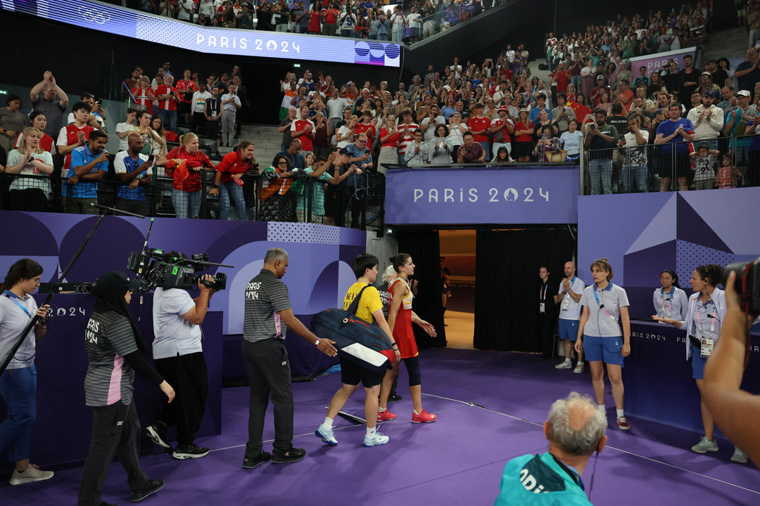 La jugadora española Carolina Marín (c) abandona la pista seguida de la china Bing Jiao He, tras verse obligada a retirarse, debido a una lesión, en el pabellón a Chapelle Arena en la capital francesa. EFE/ Miguel Gutiérrez