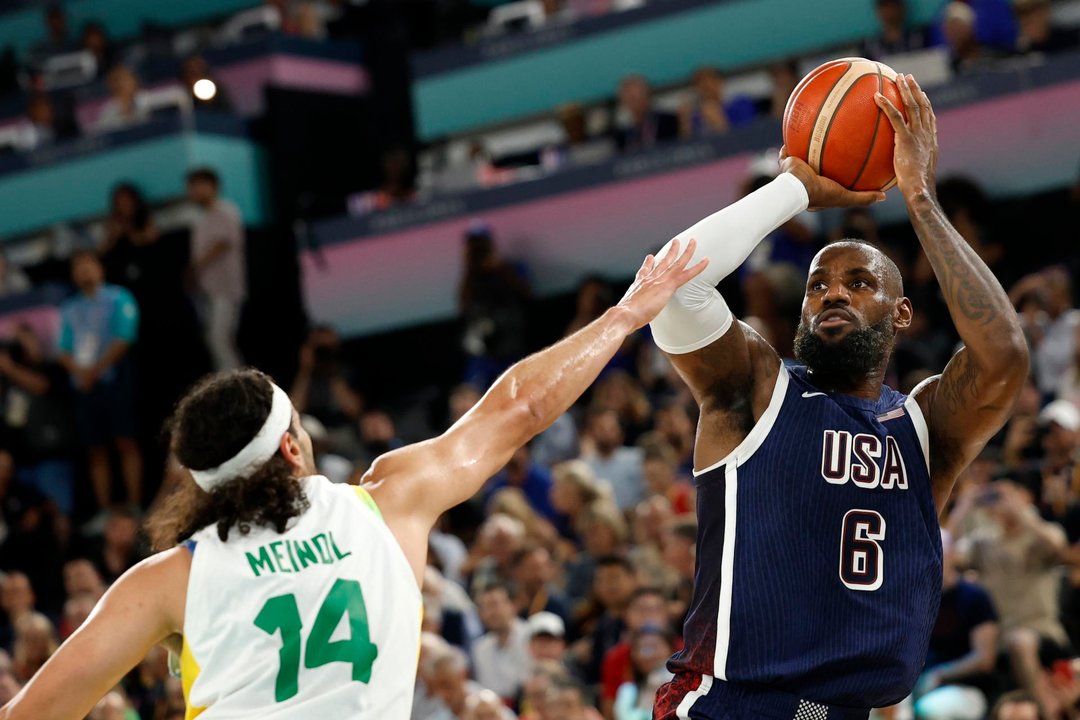 El jugador estadounidense LeBron James (d) trata de anotar ante el defensa brasileño Leo Meindl en el South Paris Arena en Paris, Francia. EFE/EPA/CAROLINE BREHMAN