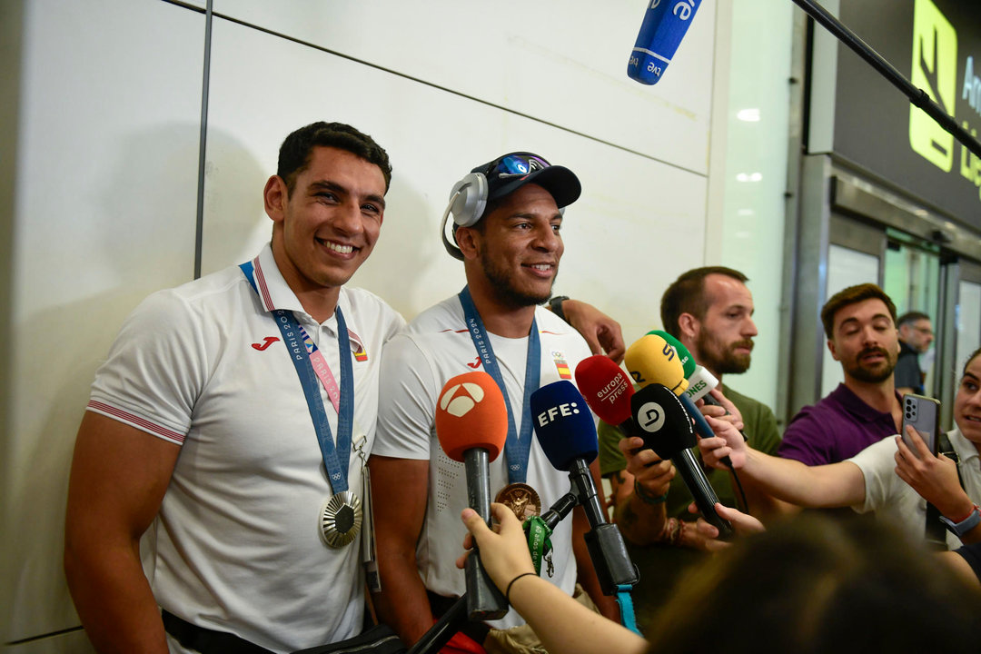 Los boxeadores Ayoub Ghadfa (i) y Enmanuel Reyes Pla posan con sus medallas conseguidas en París a su llegada este domingo a Madrid. El boxeo español llegó a París 2024 con el objetivo de volver a colgarse un metal, a pesar de que no lo conseguía desde Sídney 2000. EFE/ Victor Lerena