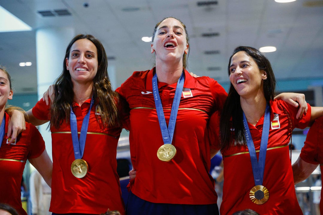 Las jugadoras Anni Espar (i), Maica García (c) y Pili Peña (d) a la llegada de la selección española femenina de waterpolo, actual campeona olímpica, al aeropuerto de Barcelona, este lunes. EFE/ Quique García