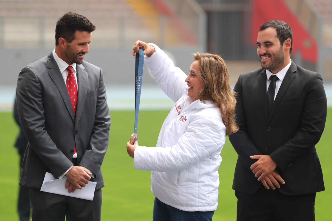 La presidenta de Perú, Dina Boluarte (c), entrega los Laureles Deportivos al velerista Stefano Peschiera (i) en Lima (Perú). EFE/ Paolo Aguilar