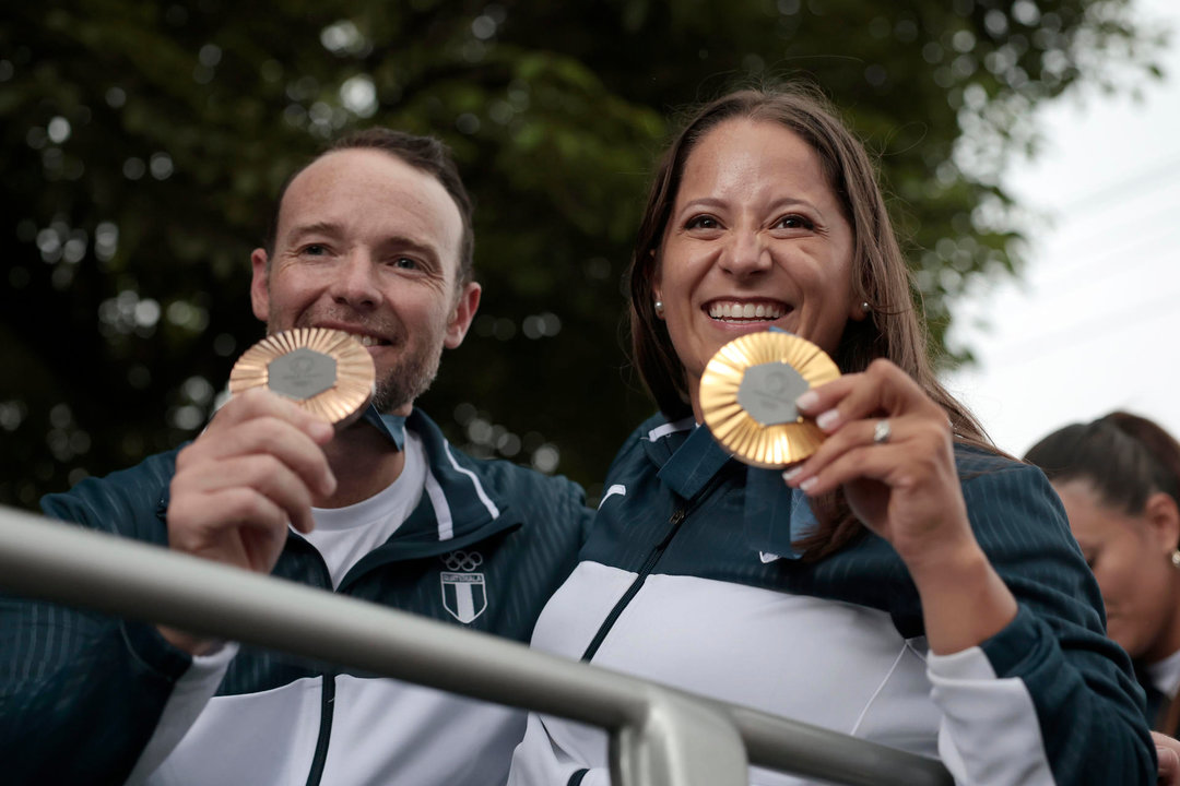 Los tiradores guatemaltecos Adriana Ruano (d) y Jean Pierre Brol, medallistas olímpicos en las pasadas justas de París, fueron registrados este miércoles, 14 de agosto, la exhibir sus preseas, durante una caravana de bienvenida, por las calles de Ciudad de Guatemala (Guatemala). EFE/David Toro