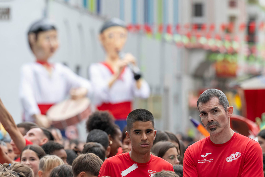 GRAF701. TORRELAVEGA, 18/08/2024.- El atleta Mohamed Attaui (i) durante el desfile de la Gala Floral, acompañado por todos los miembros de la Escuela Deportiva Municipal de Atletismo, este domingo en la ciudad cántabra de Torrelavega. EFE/Pedro Puente Hoyos