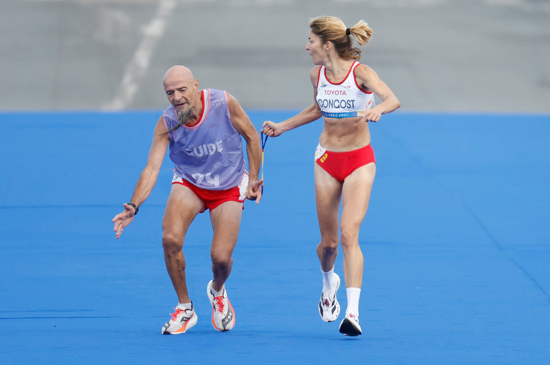 La atleta española Elena Congost, medalla de bronce en la final de la maratón T12 femenino, ayuda a su guía, que llega exhausto a la línea de meta, en los Juegos Paralímpicos de París 2024. Congost fue descalificada por soltar la cuerda que la unía a su guía, Mia Carol Bruguera, que llegó a la recta final con calambres y sufriendo en los últimos metros. EFE/ Javier Etxezarreta